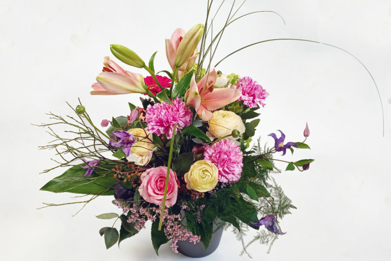 Blumenstrauß gestaffelt gebunden mit rosa Nelken, rosa Lilien, rosa Rose und cremefarbener Ranunkel