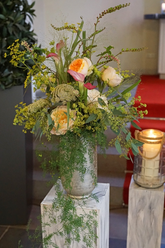 hoher Strauß mit Rosen, Calla, Alchemilla in hoher Vase auf einer Säule